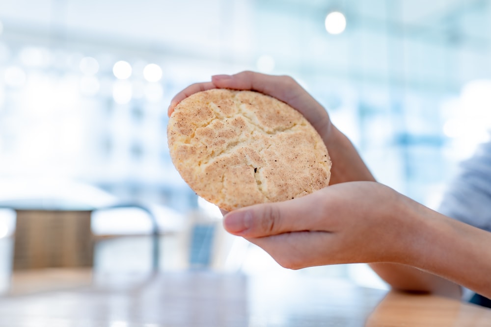 person holding brown cookie during daytime