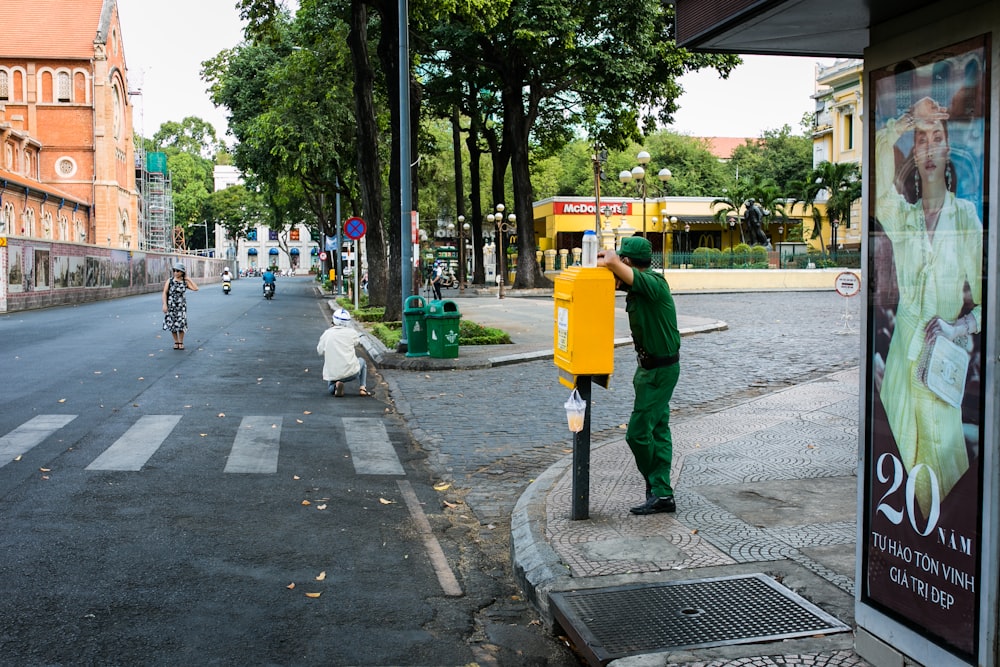 Mann in grüner Jacke und grauer Hose geht tagsüber auf dem Bürgersteig spazieren