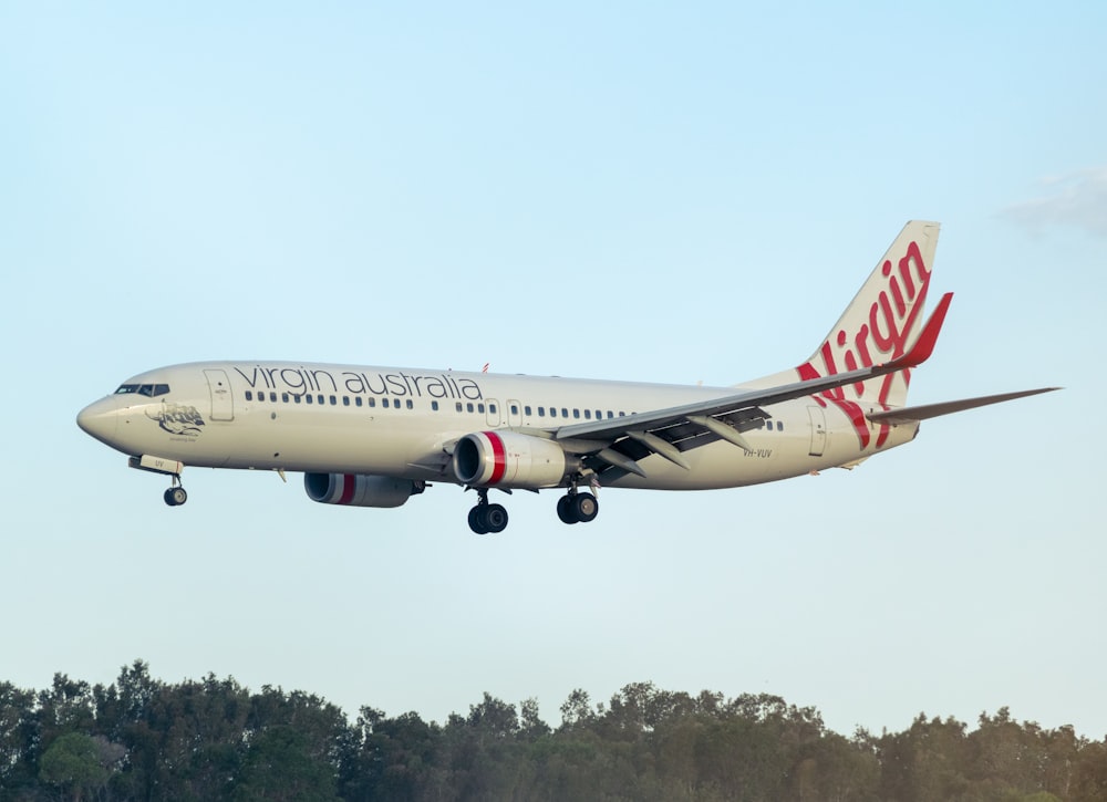 white and red air plane flying during daytime