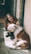 woman in black leather jacket hugging white and brown short coated dog