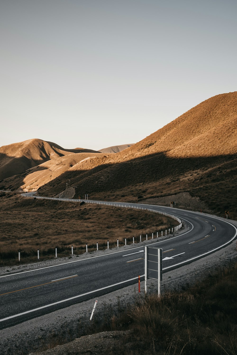 estrada de asfalto cinza entre montanhas marrons durante o dia