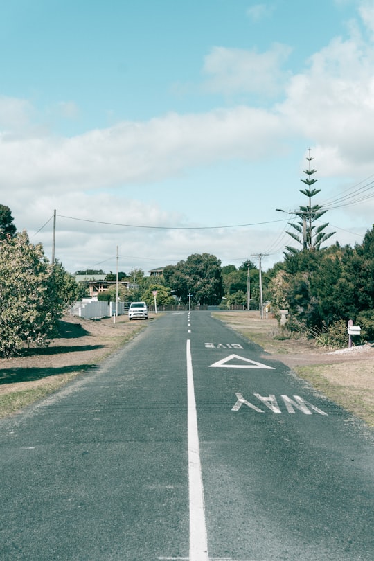 gray asphalt road with no cars during daytime in Mangawhai Heads New Zealand