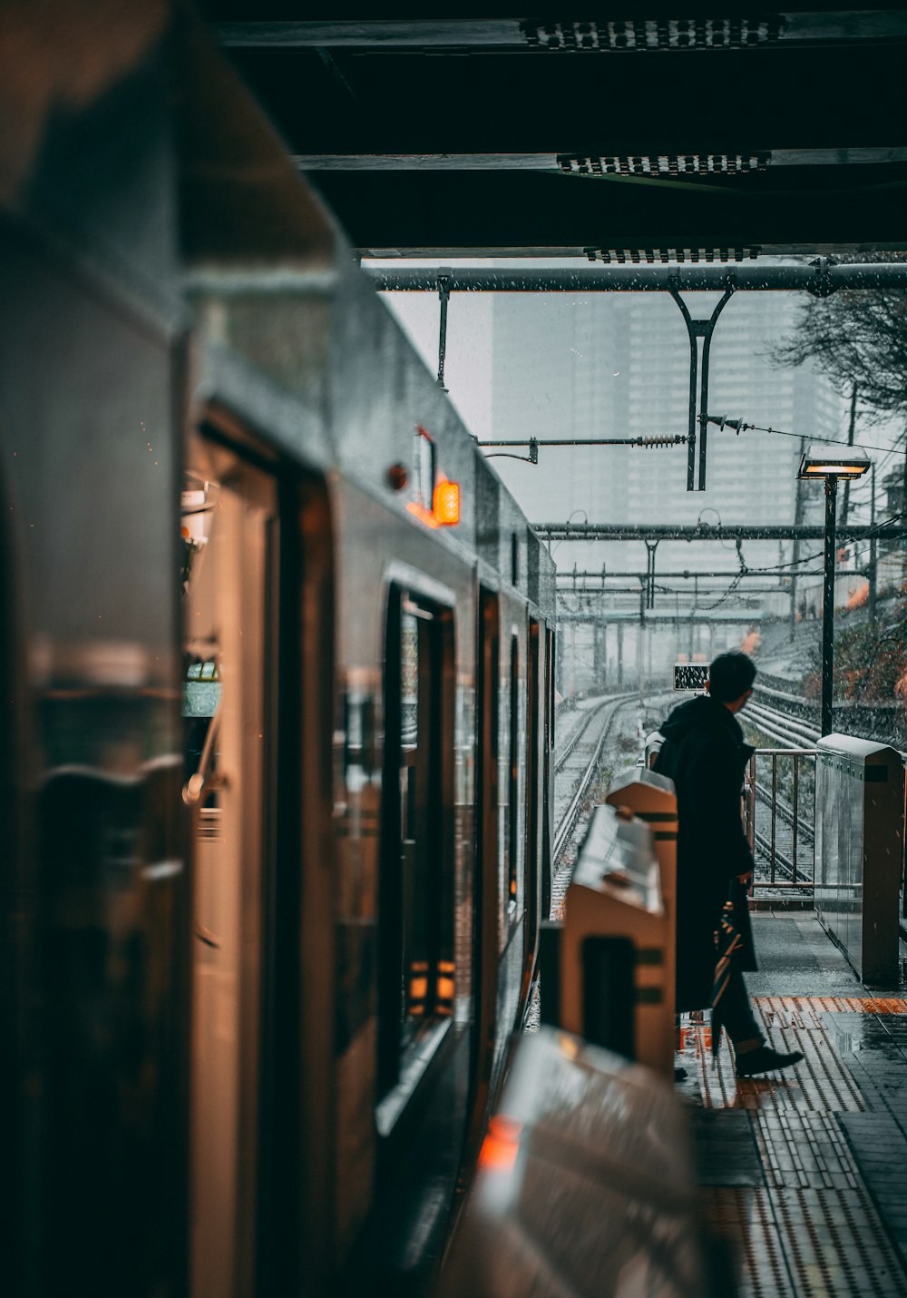 hombre con chaqueta negra de pie en la estación de tren durante el día