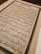 An open book with text written in Arabic script, featuring ornate calligraphy. The page is framed by an elaborate border and the content is aligned in clear rows across the page.