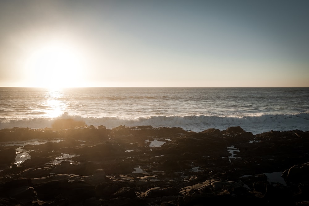 sea waves crashing on rocks during sunset