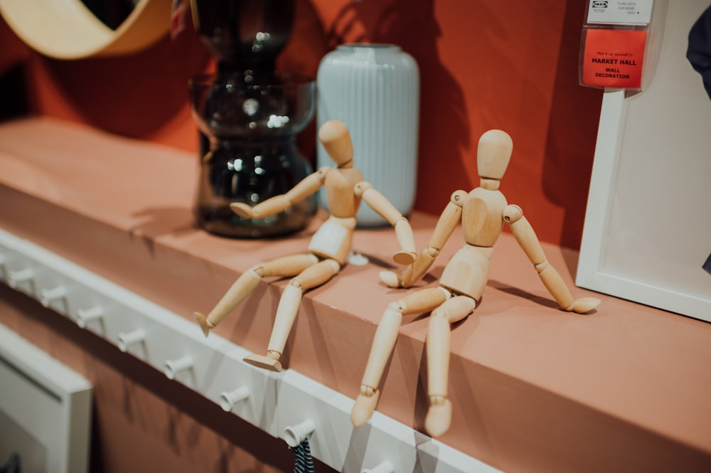 white wooden robot toy on brown wooden table