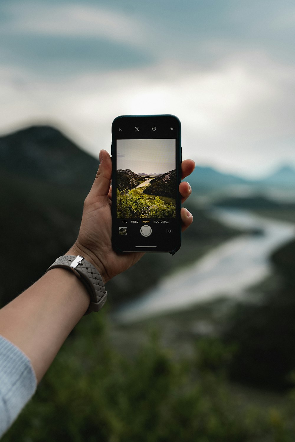 person holding black iphone 5 taking photo of body of water during daytime