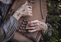 person in gray long sleeve shirt playing string instrument