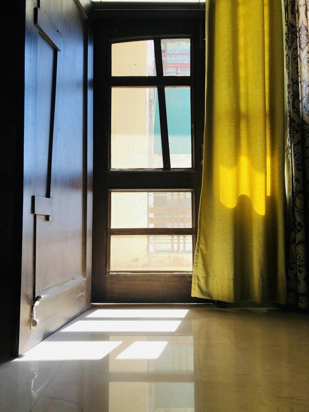 brown wooden door with yellow curtain