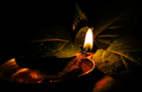 Close-up of a delicate Tamil-scripted palm leaf illuminated by soft candlelight.