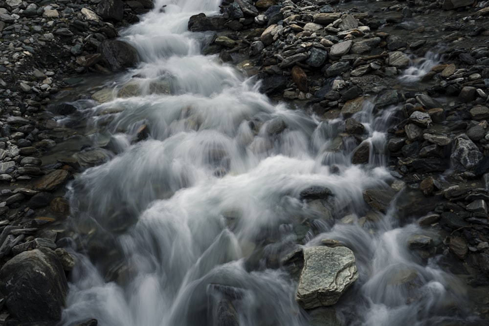 water falls on rocky shore during daytime