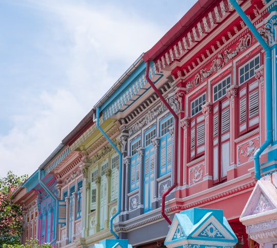 red and white concrete building under white clouds during daytime in Peranakan Houses Singapore