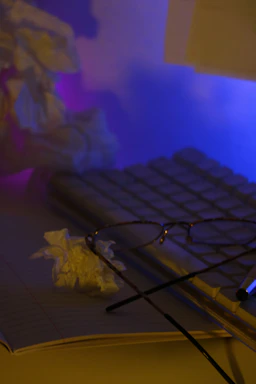 A calm workspace with a notebook, glasses, and a soft light, suggesting a thoughtful approach to understanding neurodiversity.