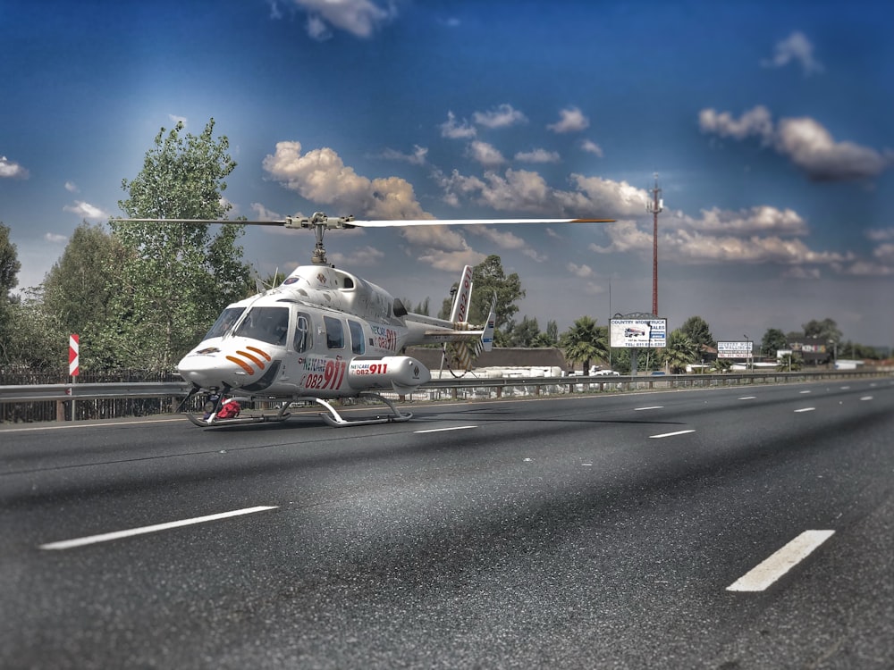 white and red airplane on gray asphalt road under blue sky during daytime