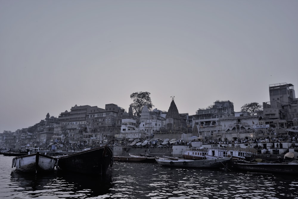 black boat on body of water near city buildings during daytime