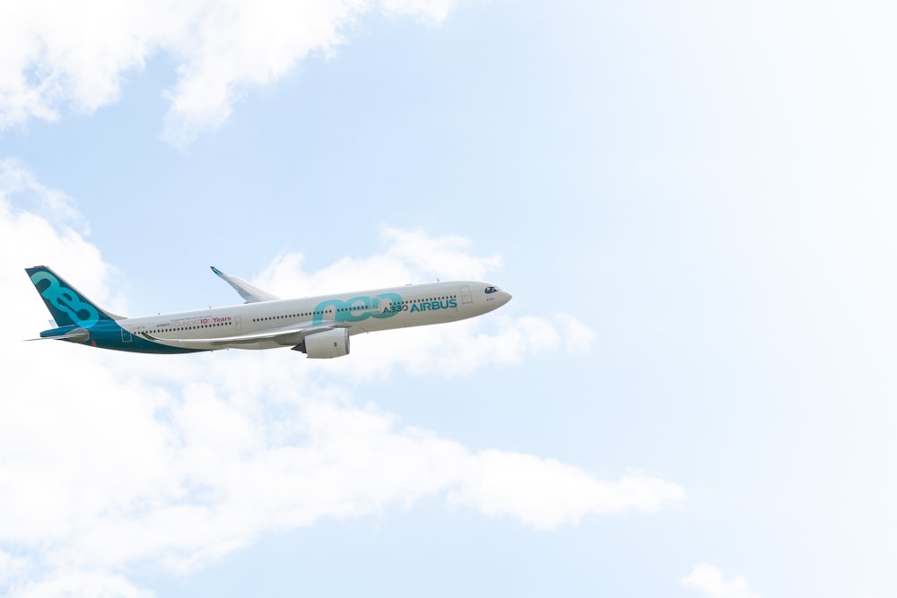 white and blue airplane flying during daytime