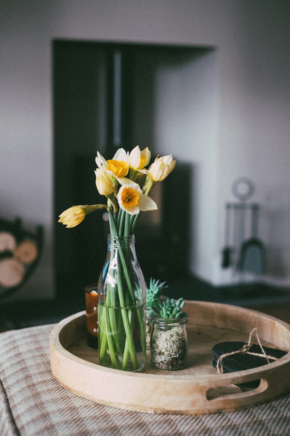 yellow daffodils in clear glass vase on brown wooden table