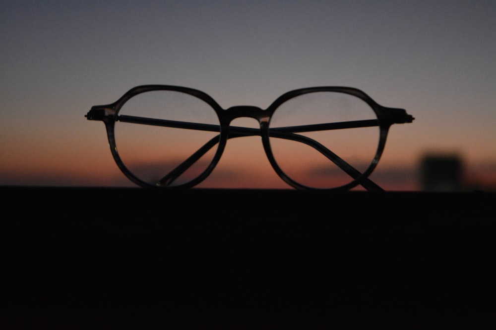 black framed eyeglasses on black surface