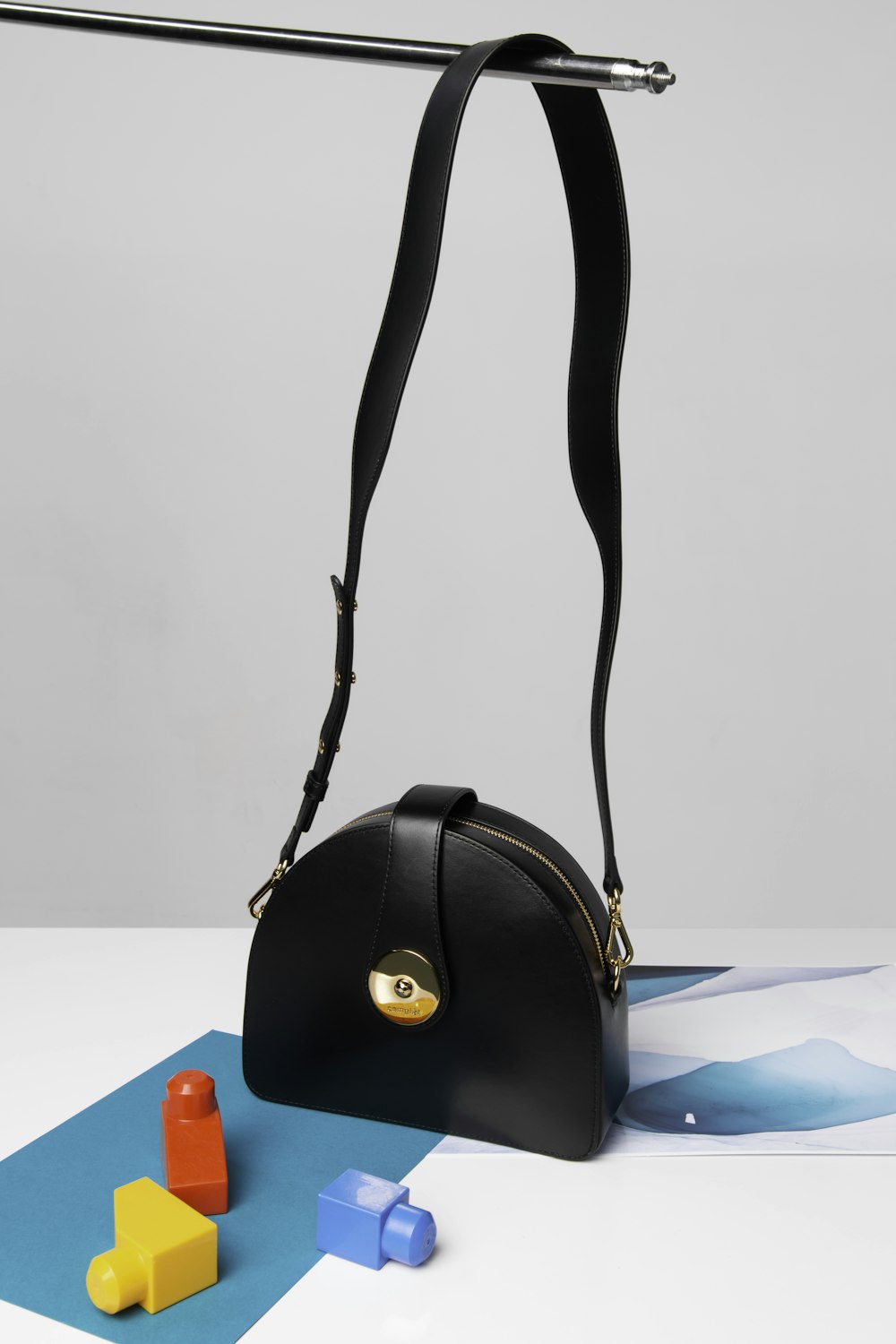 black leather handbag on white table