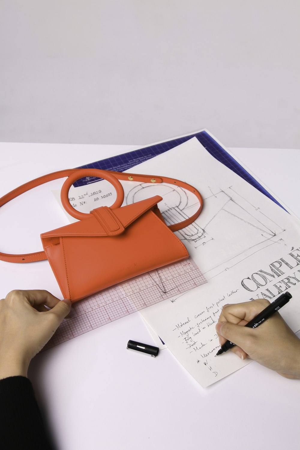 person holding red leather handbag