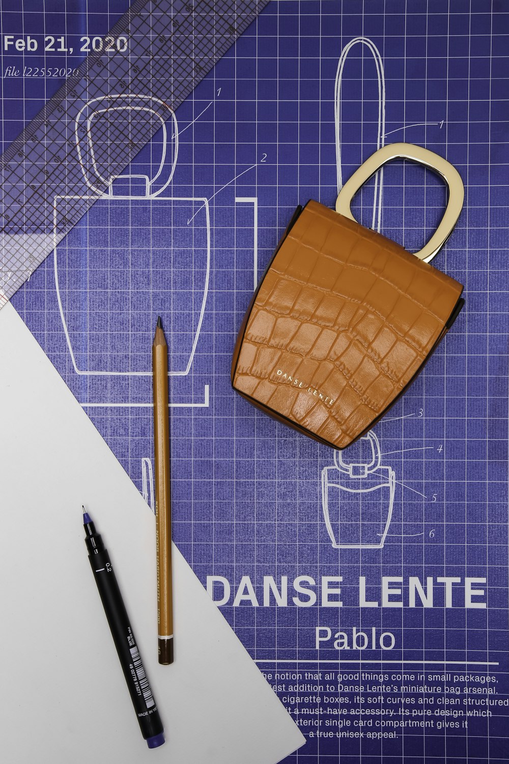 brown leather handbag beside black click pen