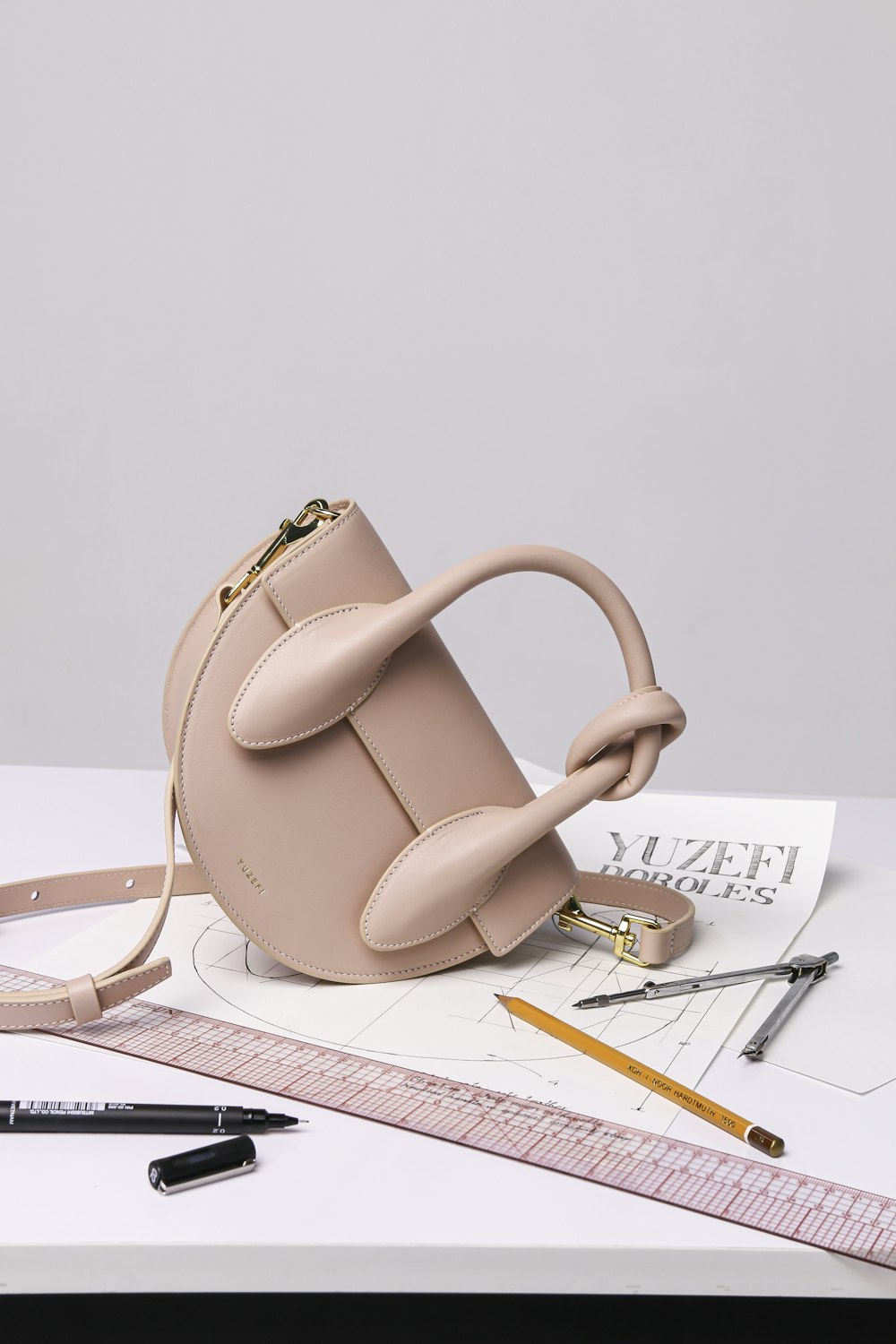 brown leather handbag on white ruled paper