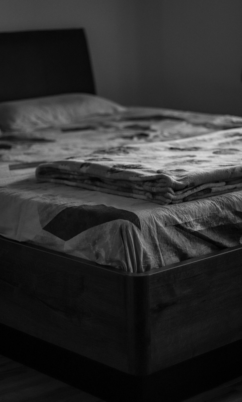 grayscale photo of bed with white and black blanket
