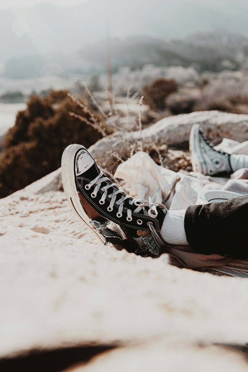 person wearing black and white converse all star high top sneakers