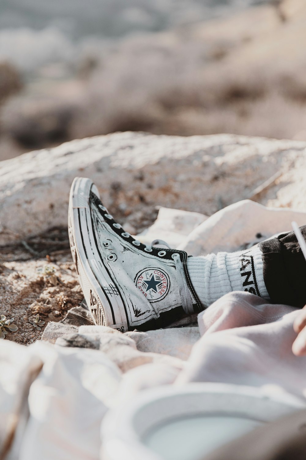 person wearing black and white converse all star high top sneakers