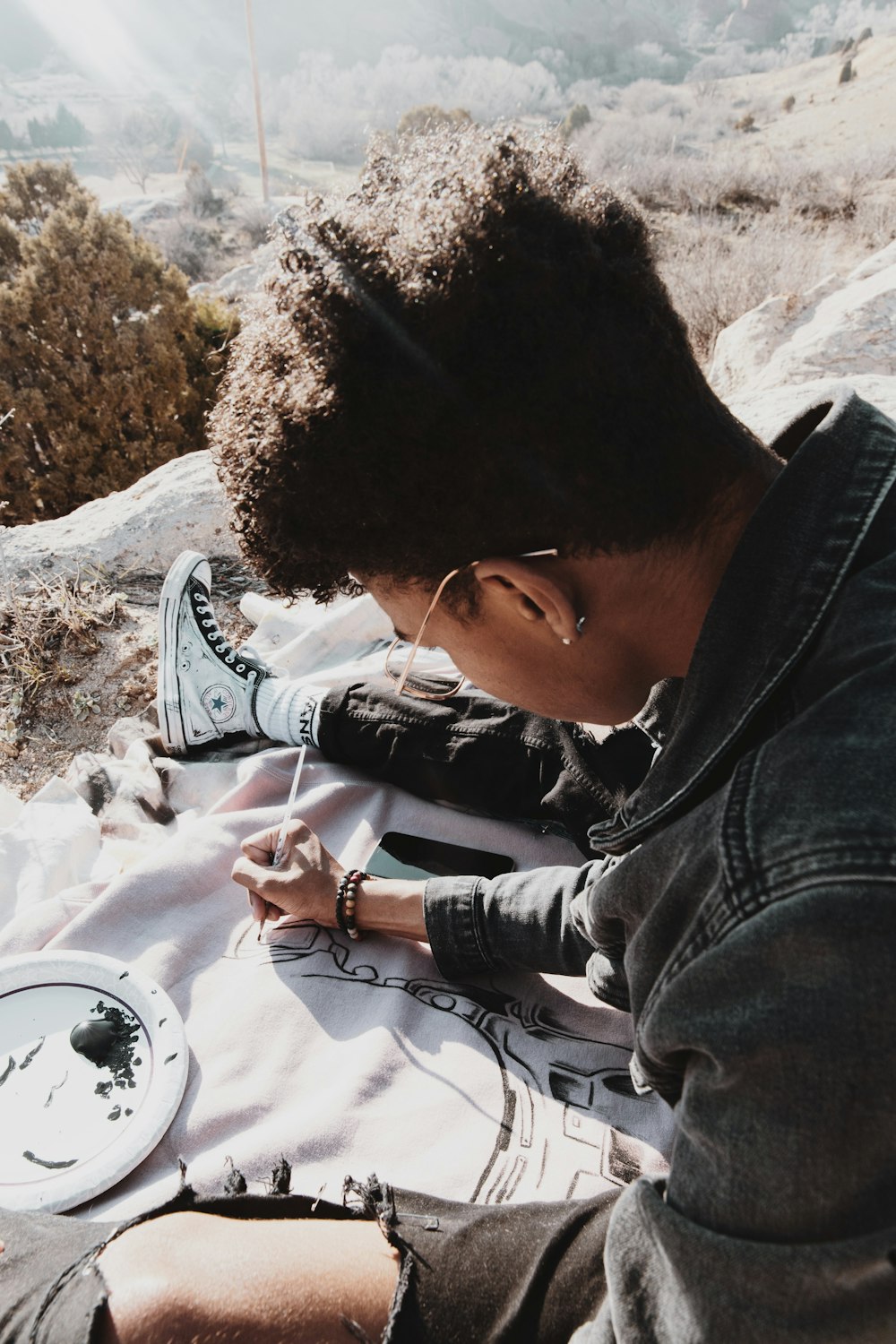 man in gray hoodie writing on white paper