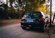 Wide shot of a car parked on a quiet street with the inspector taking notes.