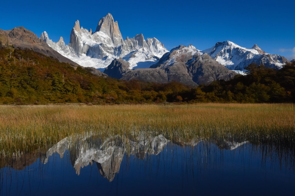 snow covered mountain near lake during daytime