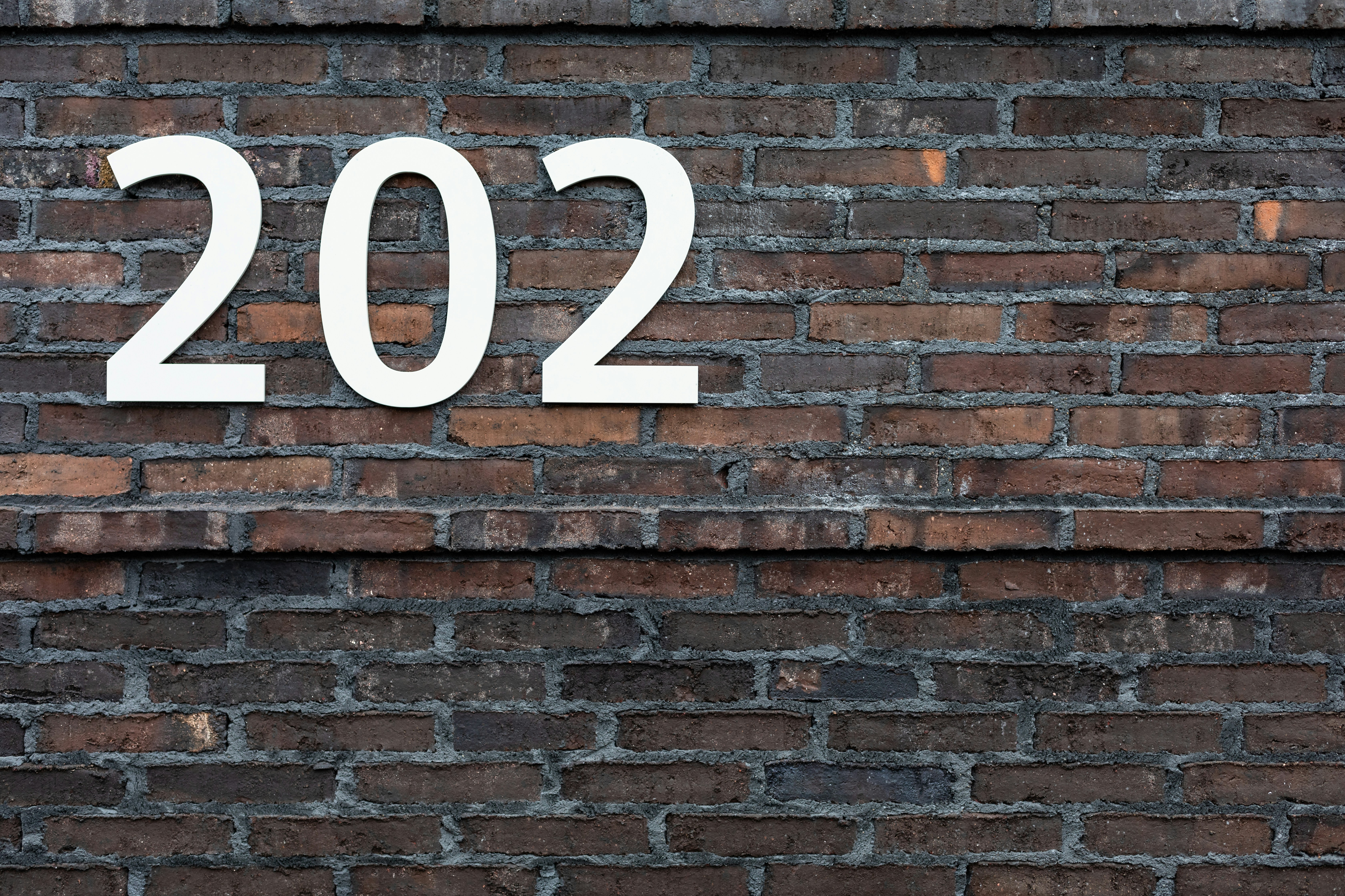 brown brick wall with white and black no smoking sign
