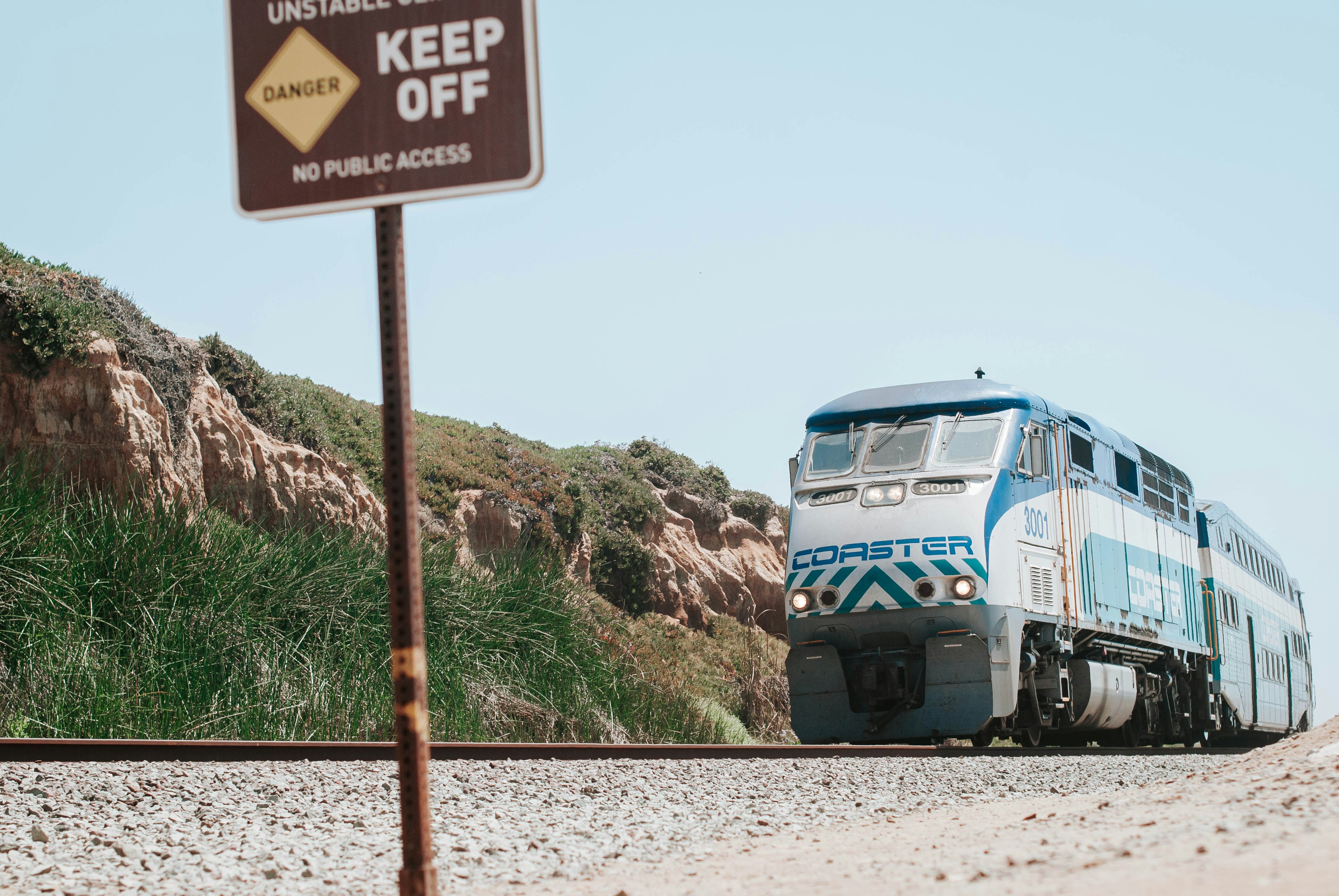 blue and white train on rail road during daytime