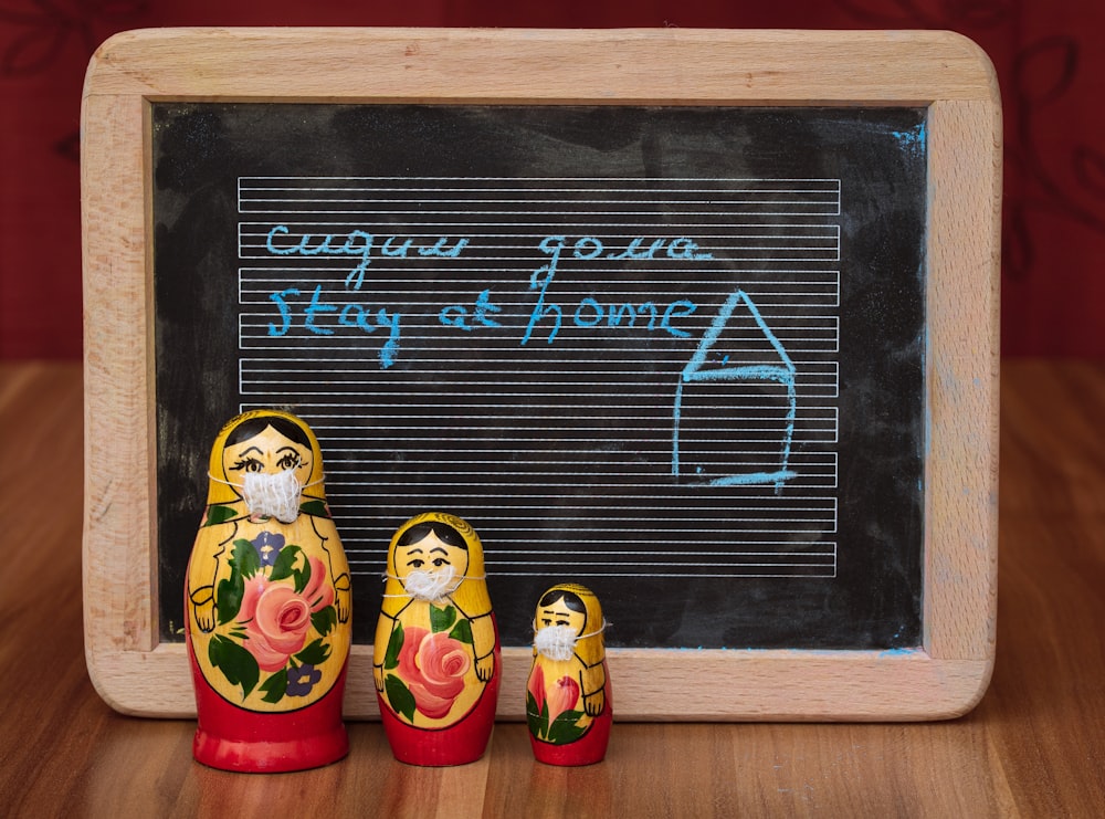 two minion figurines on black and white chalk board