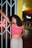 woman in red crop top and blue denim shorts standing near red neon sign