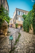 woman in green coat walking on pathway during daytime