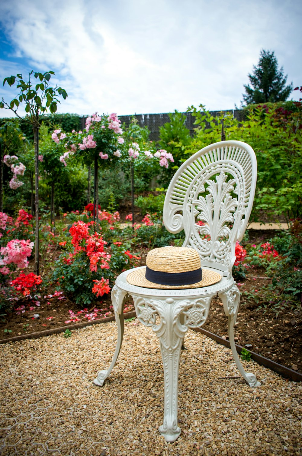 white wicker chair near red flower