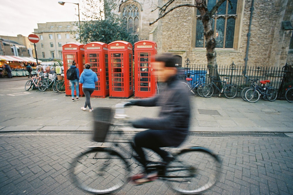 man in black jacket riding bicycle on sidewalk during daytime