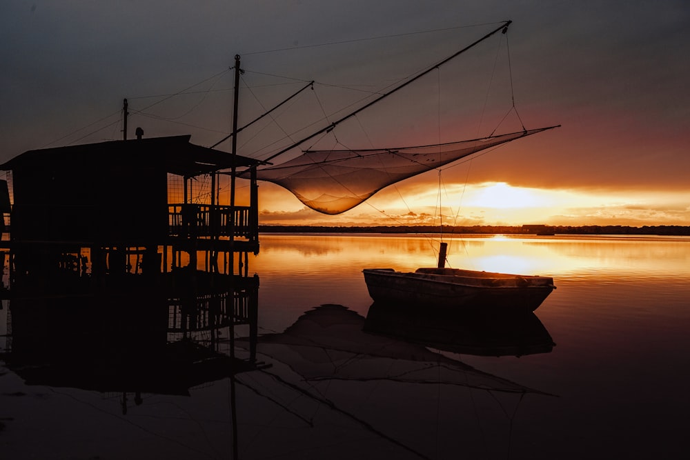 silhouette of boat on sea during sunset