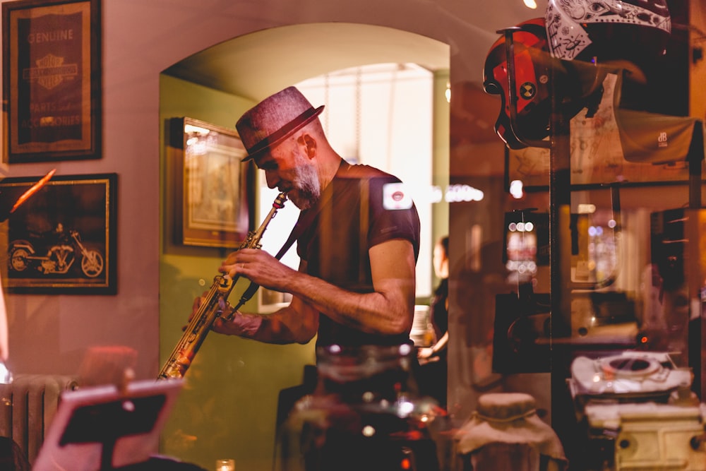 man in black tank top playing trumpet