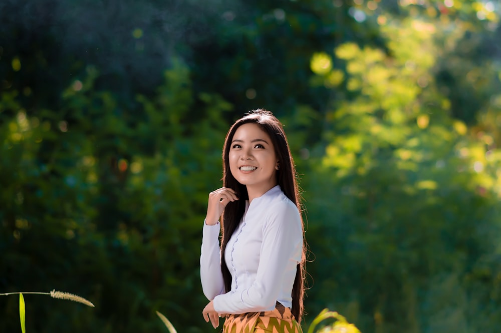 woman in white long sleeve shirt smiling