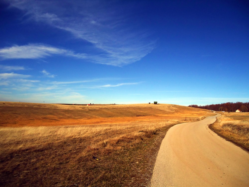 Campo marrón bajo el cielo azul durante el día