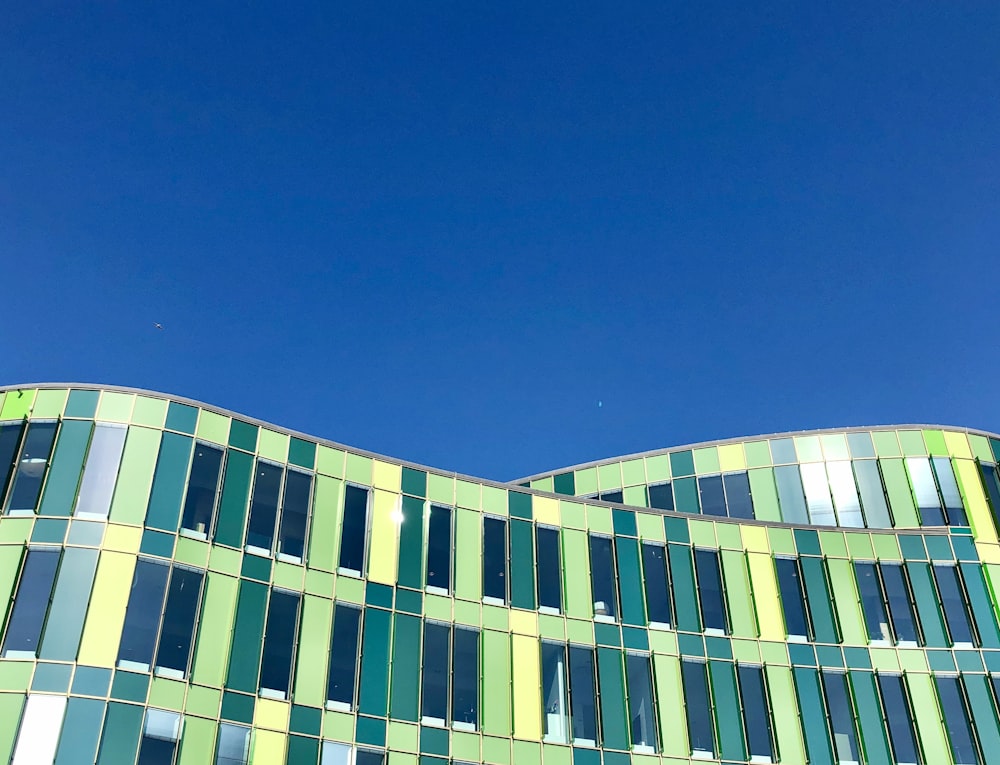 Edificio in calcestruzzo bianco e verde sotto il cielo blu durante il giorno
