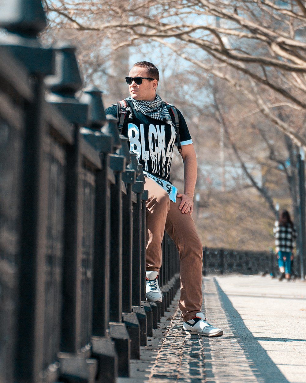 woman in black and white crew neck t-shirt and brown shorts standing on gray concrete