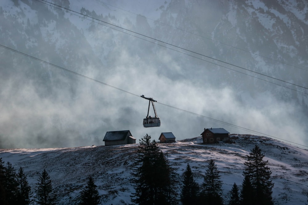 black cable car over snow covered mountain