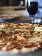 Close-up of a wood-fired pizza with fresh basil and melted cheese.