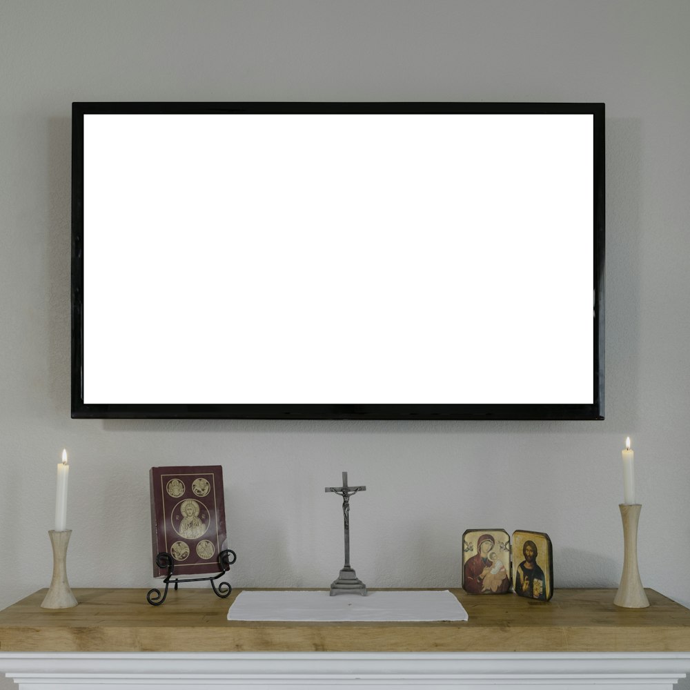Televisor de pantalla plana negro montado en pared blanca