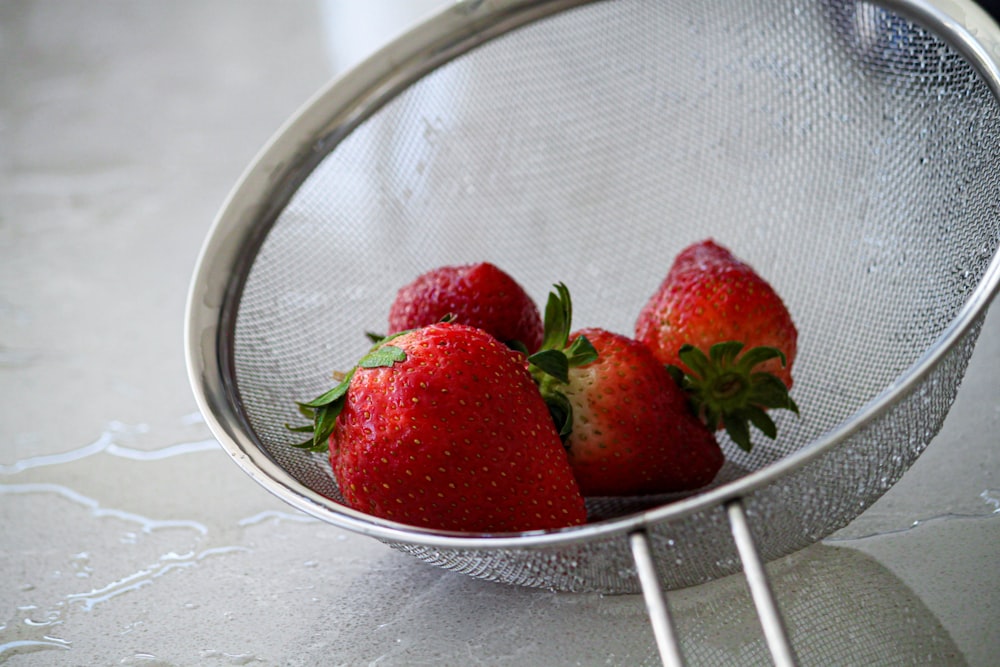 red strawberries in stainless steel strainer