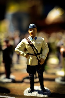 A close-up of a vintage military uniform with a subtle, suggestive silhouette in the background.